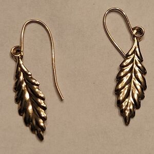 Gold dangle earrings featuring a naturalistic leaf motif.